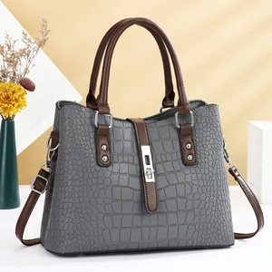 Grey crocodile texture handbag with brown contrast handles and silver hardware lock