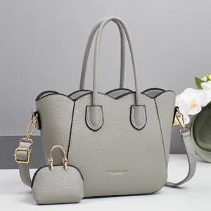 Dettaglio della borsa tote grigia con bordo smerlato e mini ciondolo portamonete