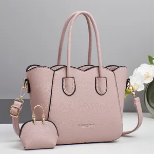 Dettaglio della borsa tote rosa con trama litchi e mini portafoglio coordinato