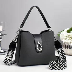 Textured black handbag with stylish geometric patterned wide shoulder strap and silver clasp