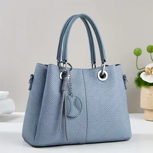 Elegant misty blue tote bag with geometric embossed pattern and silver hardware