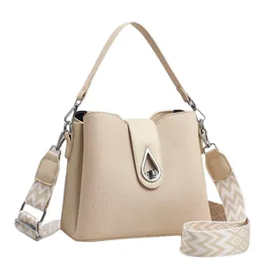 Chic beige bucket bag with woven canvas texture, silver teardrop lock and wide woven strap