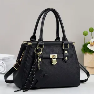 Large black embossed leather tote bag with gold hardware and removable shoulder strap