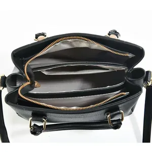 Top view detail of the black lychee leather bag interior with three spacious compartments