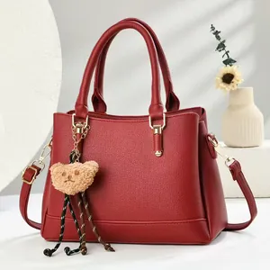 Vintage red Boston handbag in pebbled leather with a cute bear charm and gold hardware