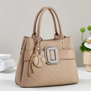 Elegant beige tote bag with geometric embossing and diamond-encrusted strap detail