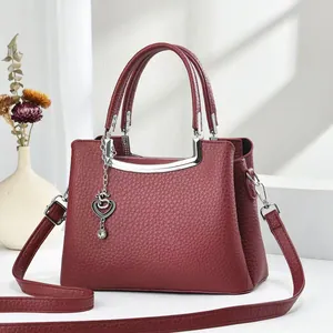 Sac à main élégant en cuir bordeaux avec breloque cœur et bandoulière réglable