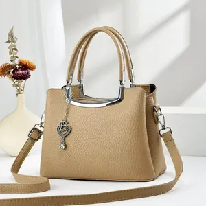 Sac à main élégant en cuir grainé beige avec pendentif cœur et bandoulière réglable