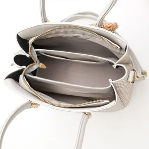 Internal structure of woven handbag featuring multi-compartment design and gold hardware