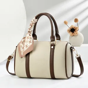 Detalle de bolso boston beige de piel lichi con pañuelo de seda en el asa