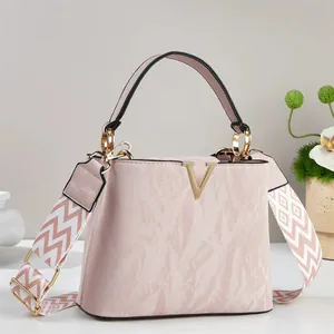 Elegante borsa a mano rosa con decorazione a V dorata e tracolla a zigzag