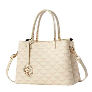 Beige two-tone handbag with geometric patterns and petal pendant shown at a 45-degree angle