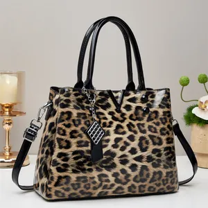 Detailweergave van luipaardprint handtas met lakafwerking en metalen V-vormige decoratie