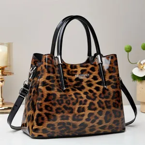 Elegante bolso tote de leopardo en charol brillante con asa superior y correa larga