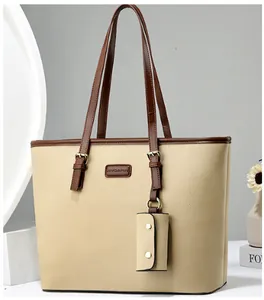 Detail of beige tote bag with brown straps and matching small card pouch on display