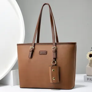 Detail of brown litchi pattern leather tote bag with small matching pouch and gold buckle