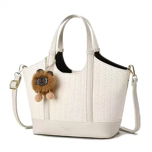 Minimalist beige woven tote bag with a cute plush bear pendant and adjustable strap