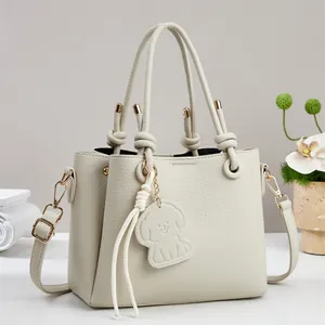 Elegant beige lychee texture bucket handbag with cute dog charm and floral decoration