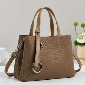 Detailed view of brown tote bag with V-shaped woven texture and silver metal ring