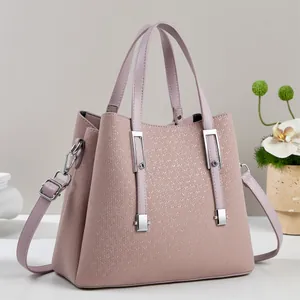 Detail shot of the textured grain leather and silver hardware on this soft pink handbag