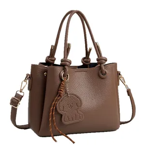 Brown lychee texture bucket handbag with cute puppy charm and adjustable strap