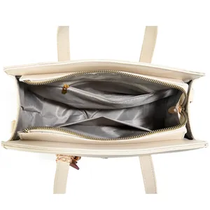 Internal view of the cream fashion handbag showing zip pocket and chevron lining
