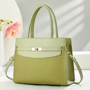 Detail of light green handbag featuring woven texture and gold metal turn-lock closure