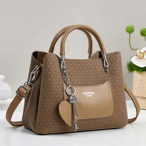 Detail of wheat texture leather handbag with heart charm and Fashion Queen logo
