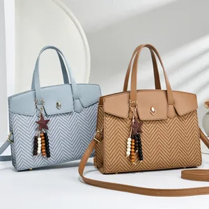 Detail of woven patchwork texture and heart-shaped gold buckle on elegant handbags