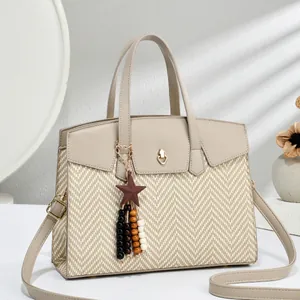 Elegant beige tote bag with woven texture, gold lock, and stylish star tassel pendant