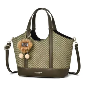 Olive green large capacity woven tote bag with leather straps and plush charm detail
