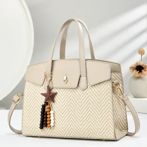 Detail of herringbone weave texture and wooden star charm on stylish satchel bag