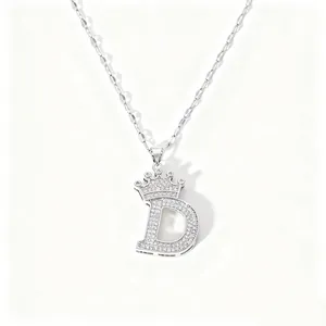 Detailed shot of a silver crown letter D pendant necklace, sparkling zircon stones, fine chain.