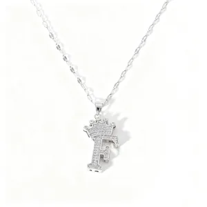 Detail view of silver crown letter F pendant necklace paved with sparkling cubic zirconia.
