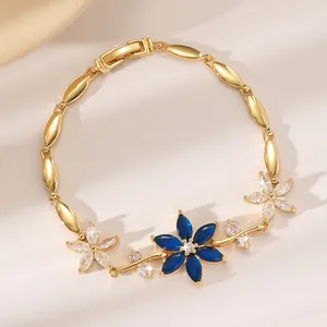 Elegantes vergoldetes Blumenarmband mit blauen Saphirsteinen und glänzenden Kristallen