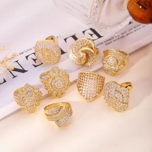 Set of 8 gold-plated rings with white rhinestones in geometric and floral designs