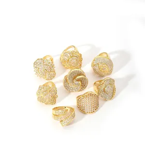 Set of 8 gold stainless steel rings featuring geometric swirl and floral crystal designs
