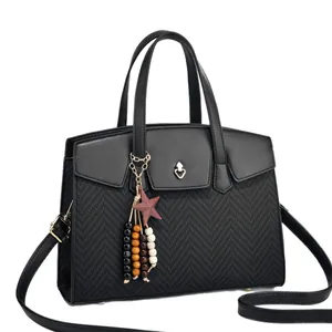 Black faux leather handbag with herringbone texture and golden heart-shaped twist lock