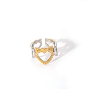 Detail view of adjustable ring featuring gold heart wings and silver cutout hearts