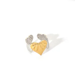 Detailed view of two-tone adjustable heart ring with gold textured heart and silver band