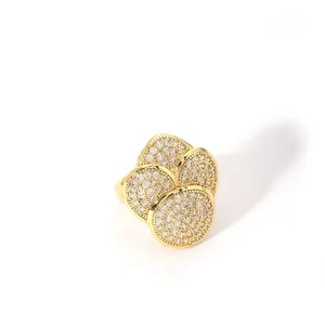 Close-up of golden multi-layered geometric ring with micro-paved white zircons