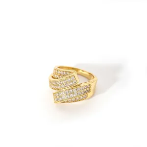 Macro detail of gold-plated bypass ring featuring triple-layered pavé-set cubic zirconia