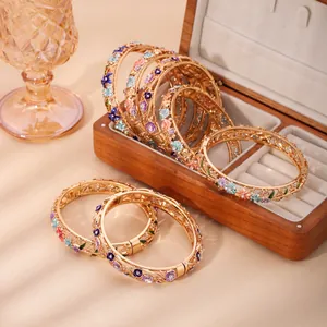 Golden hollow cloisonné bangle with colorful enamel floral details in a jewelry box