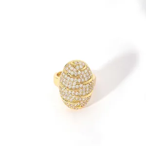 Close-up of luxury gold-plated oval ring with crystal pave setting and wave patterns