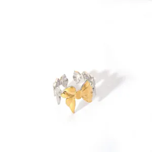Detailed macro view of bicolor bow knot ring in silver and gold stainless steel finish