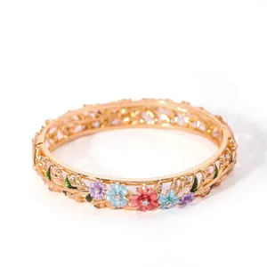 Detailed close-up of golden hollow cloisonné bracelet with colorful enamel flower patterns