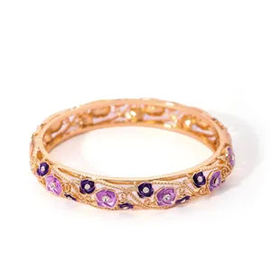 Detail of hollowed gold bangle featuring purple enamel grapes and micro-set crystals