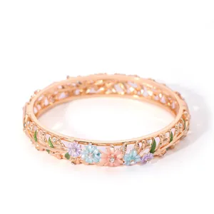Close-up of gold-plated hollow bangle with colorful floral enamel and small zircon stones