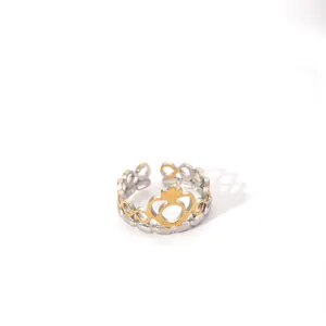 Close-up of two-tone crown ring with heart cutout and adjustable open band design