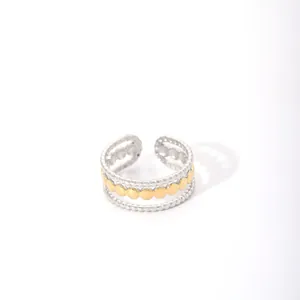 Macro shot of multi-layer geometric open ring with silver beads and gold disc accents